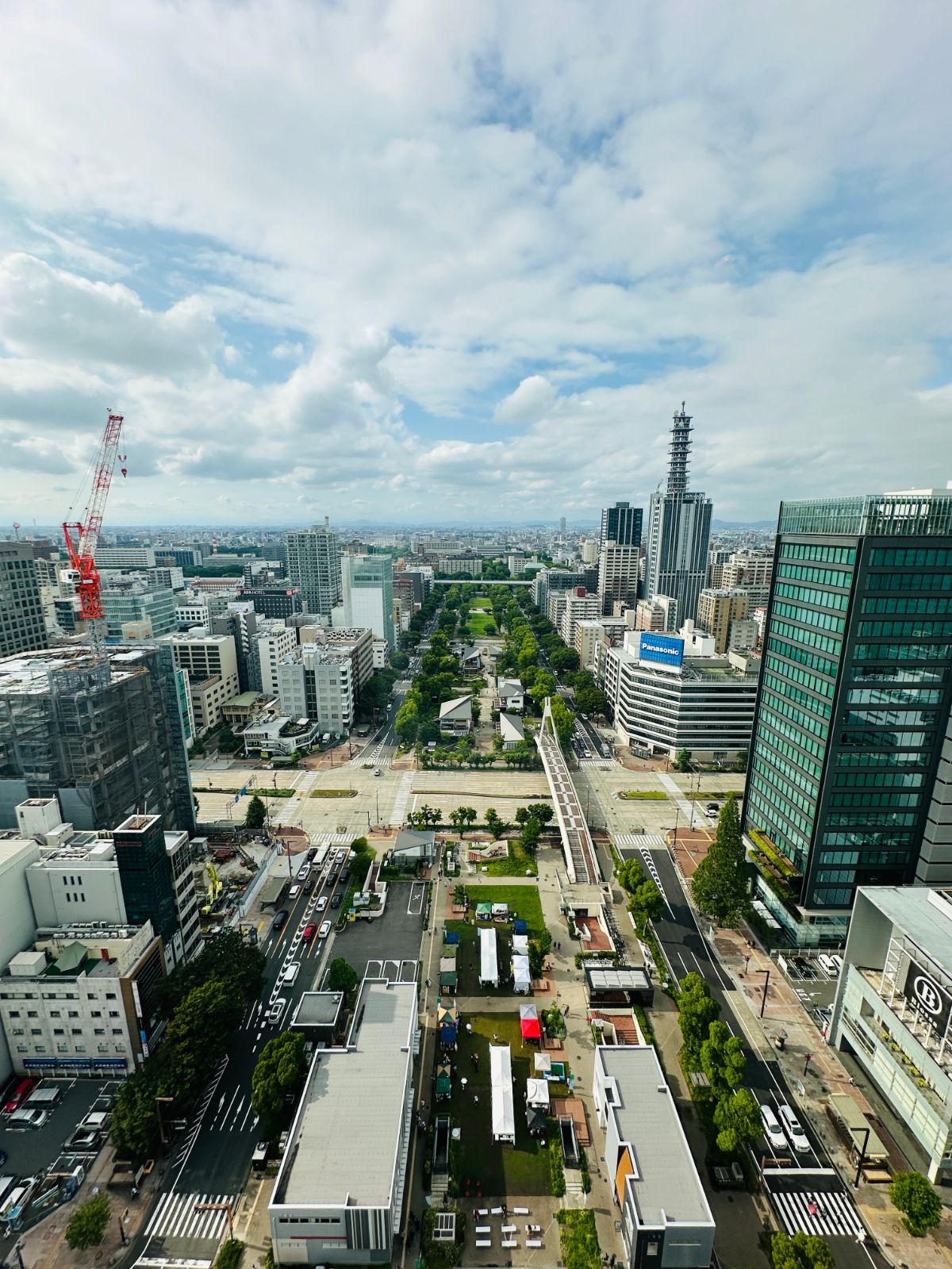 從展望台俯瞰名古屋市區，中央是狹長的綠色公園帶，兩側高樓林立，遠方是市區的天際線