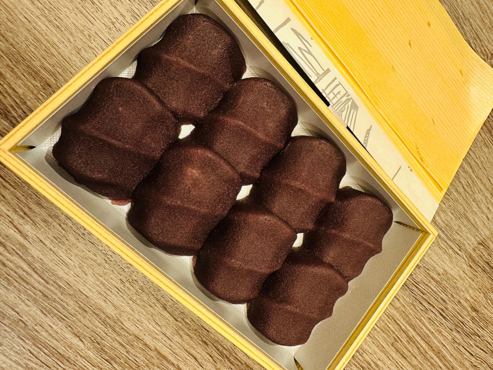 打開的木盒裡整齊排著五個深褐色的名古屋名產和菓子，表面有波浪狀的紋路