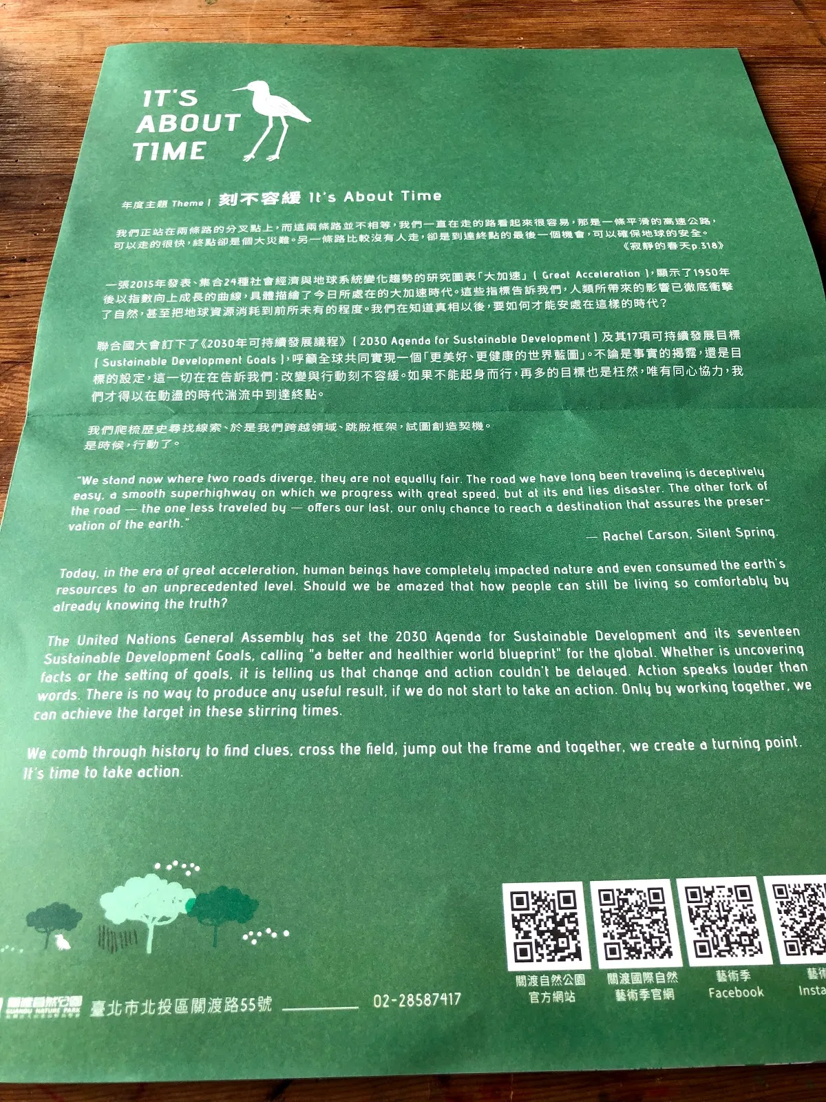 綠色的展覽看板，標題是「刻不容緩 It's About Time」，下方是中英文說明與 QR code