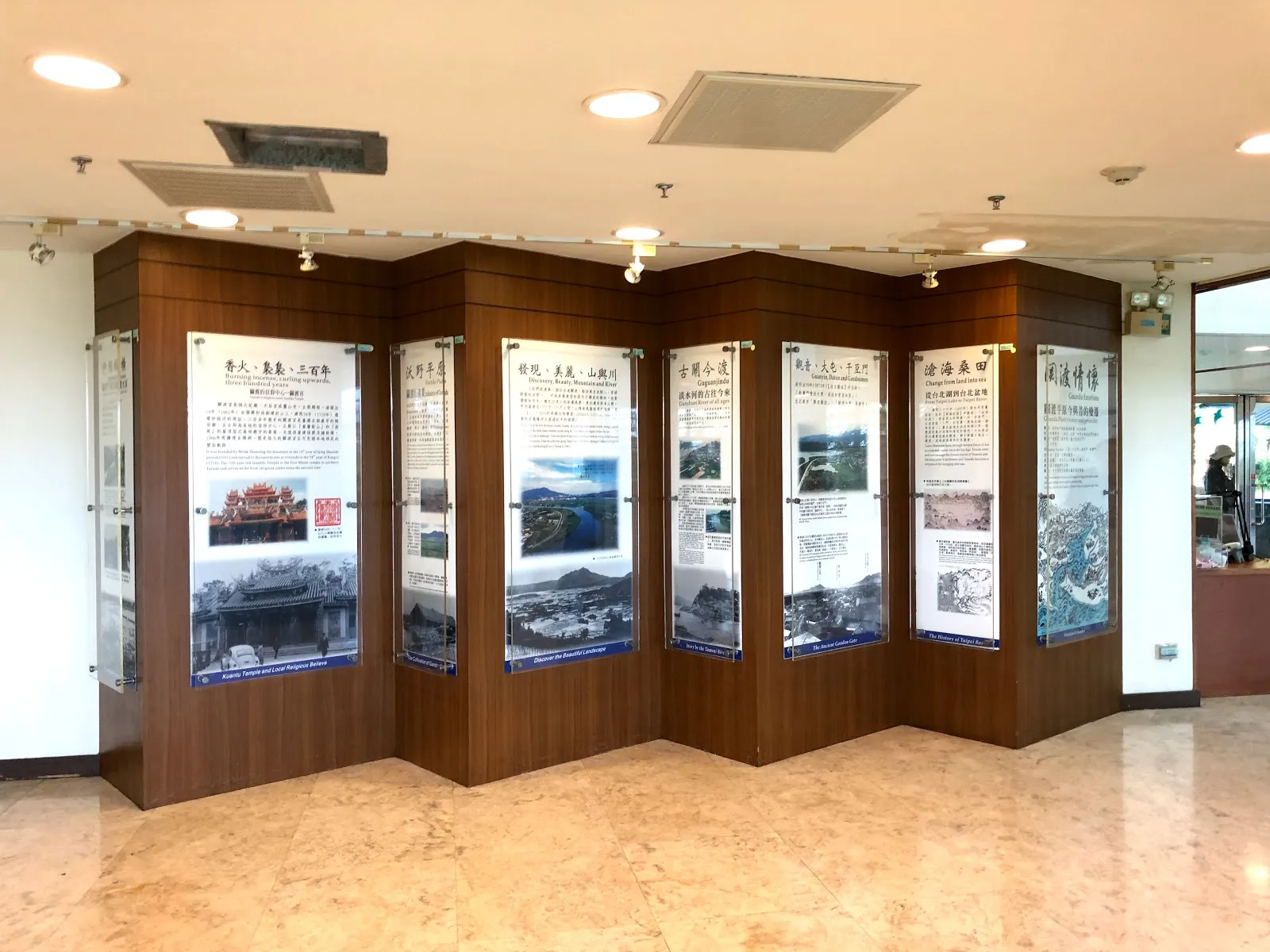 自然中心室內的展示區，木質隔板上排著一整列圖文解說看板