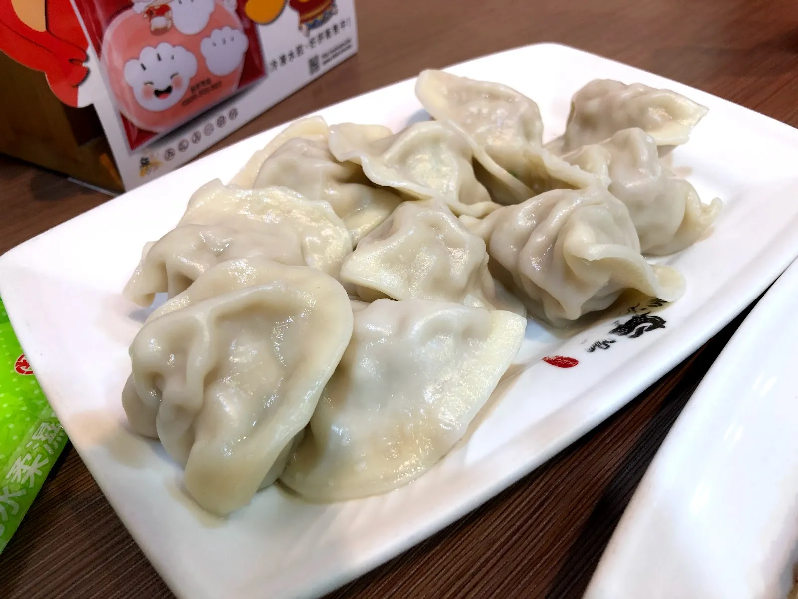 白色長盤上的一盤水餃，餃皮飽滿到透出內餡