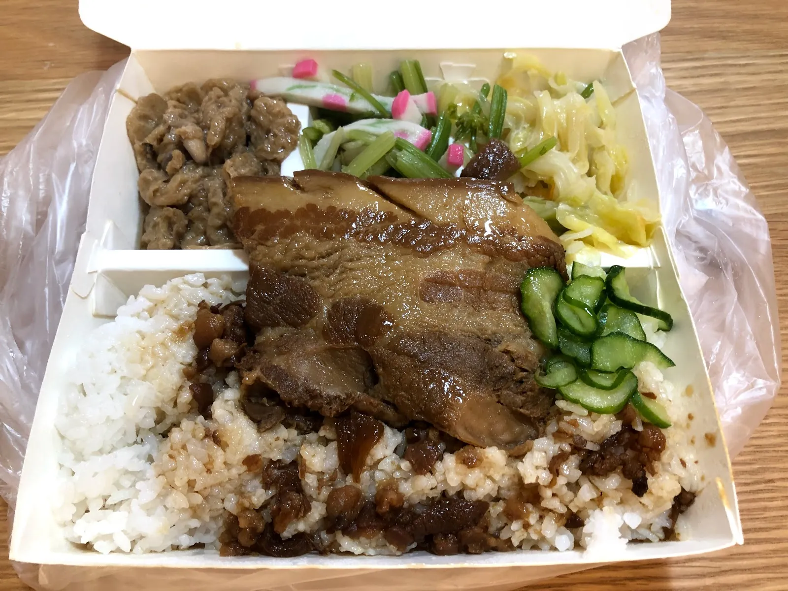 另一盒控肉飯，白飯上放著滷得油亮的控肉，配上小黃瓜片、炒青菜與豆干