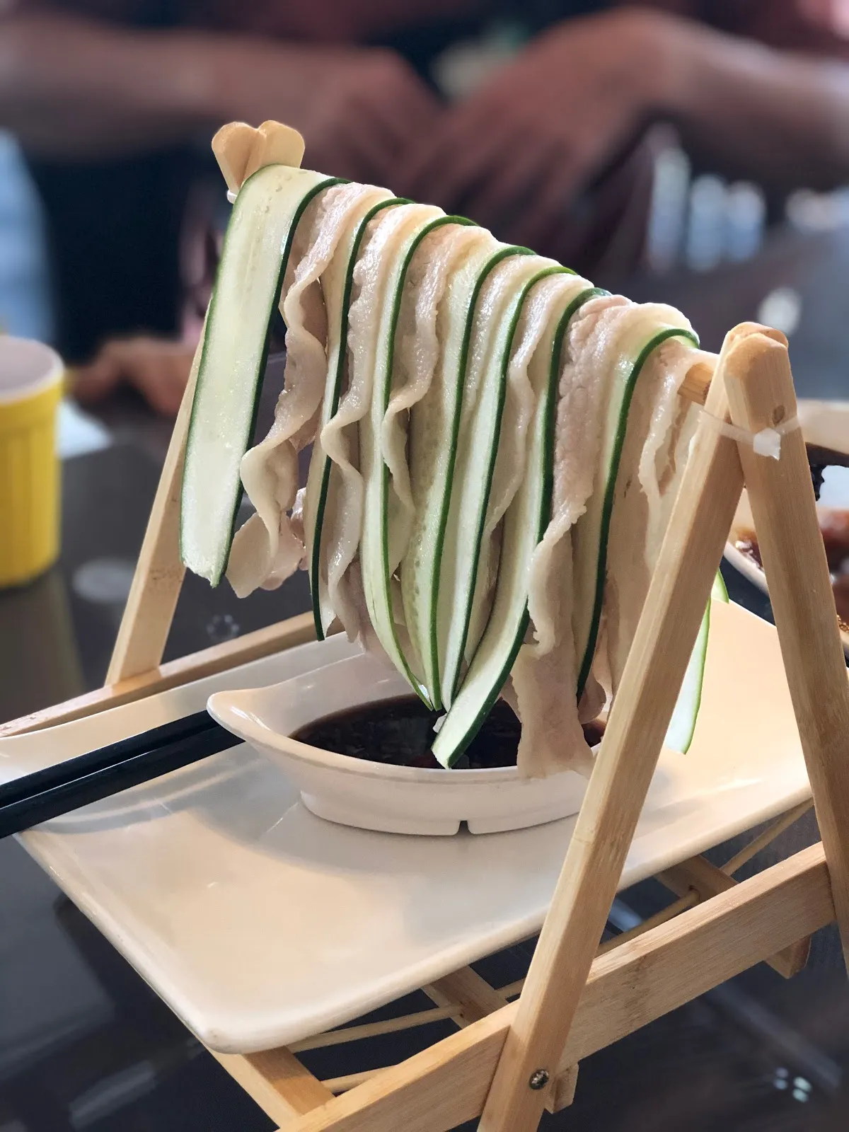 店內的兒童座椅上晾著捲成長條的小黃瓜片與白色豆皮，後方是用餐區