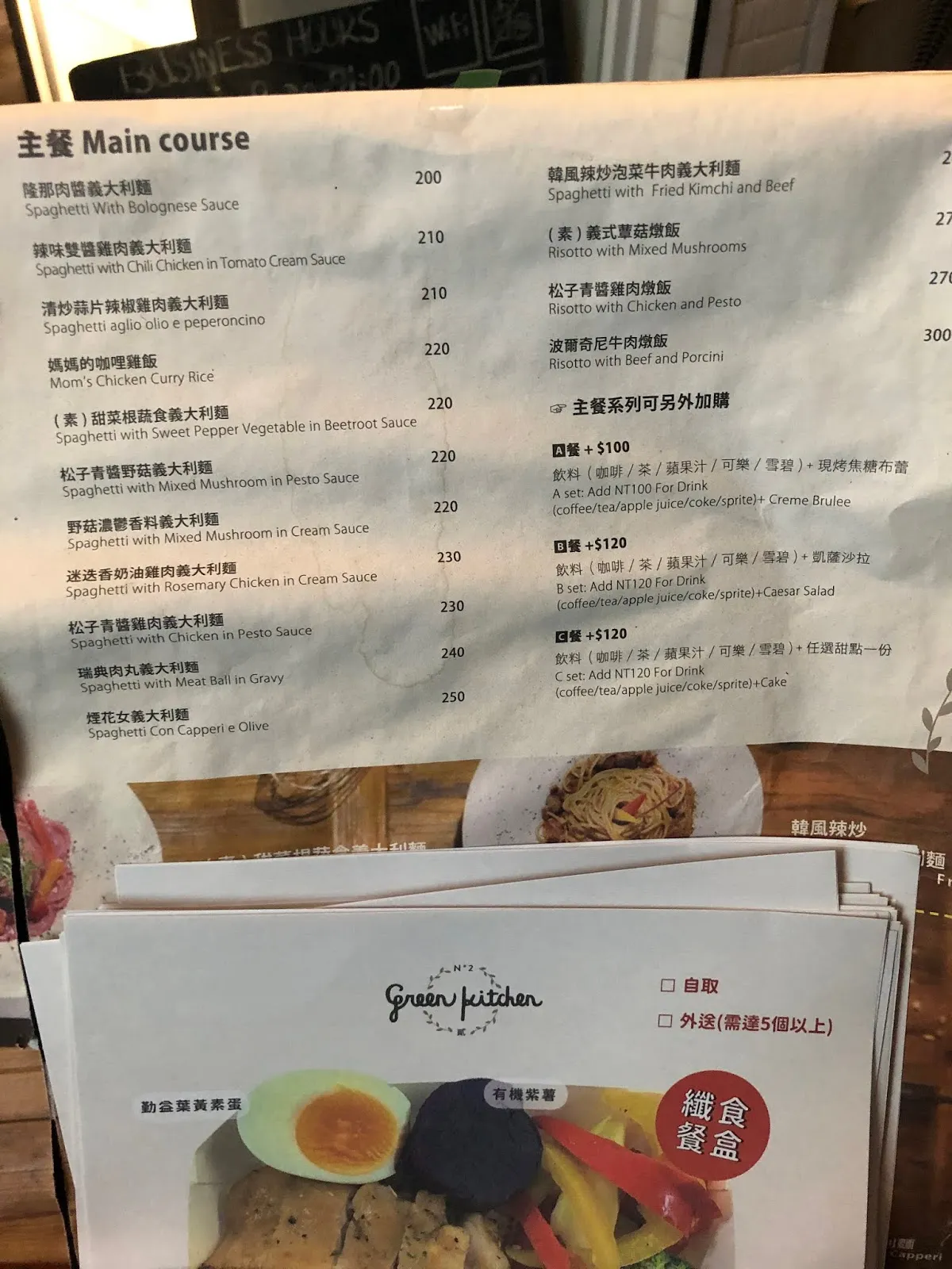 主餐菜單頁,各式義大利麵與燉飯 200 到 300 元,右下角是加價 100 元與 120 元的套餐升級說明,前方壓著 Green Kitchen 的外帶點餐單