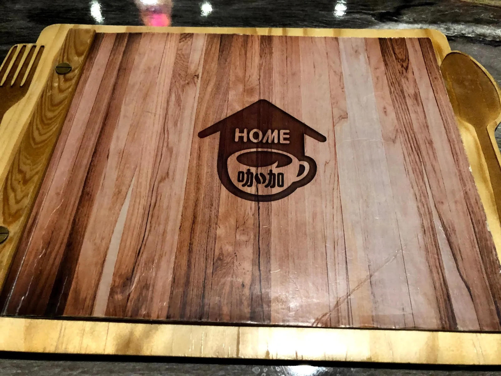 木紋托盤上印著 HOME 咖咖的 logo，一個房子外框裡放著咖啡杯