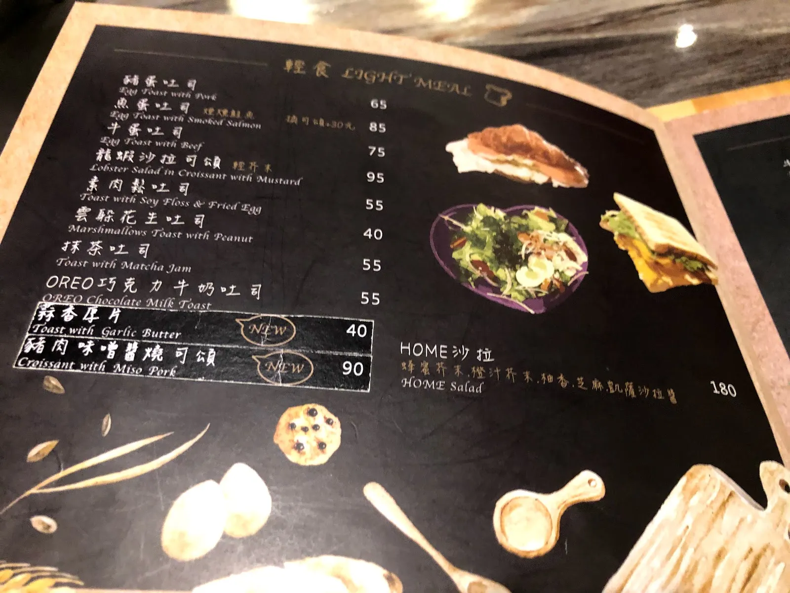 輕食菜單頁，各式蛋吐司 65 到 95 元，抹茶紅豆與 OREO 巧克力牛奶吐司 55 元，新品是蒜香奶油吐司 40 元與明太子可頌 90 元，HOME 沙拉 180 元