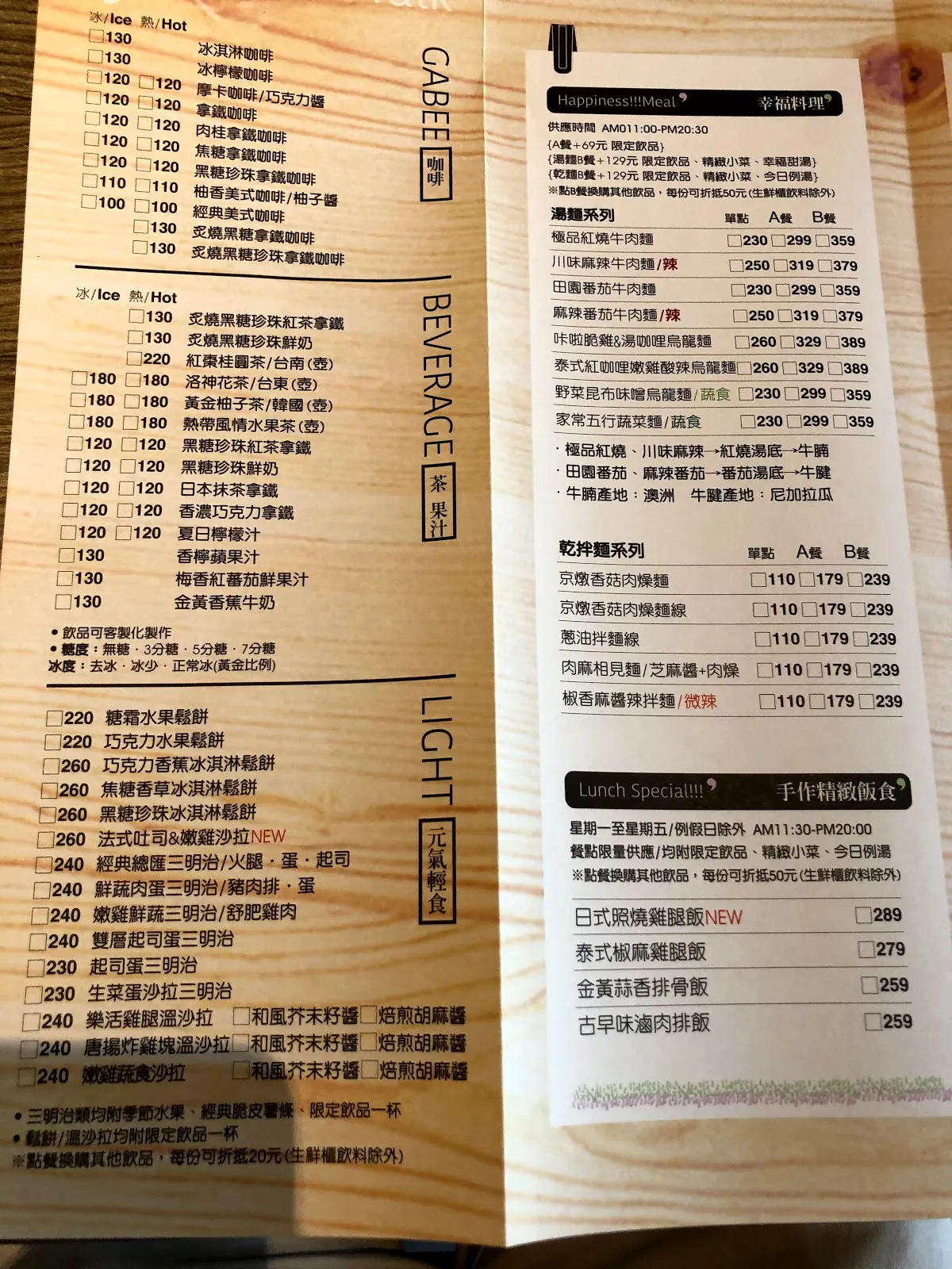 木桌上攤開的餐廳菜單，左頁是飲料與輕食價目，右頁是主餐與商業午餐，最下方是手作精緻鍋食的介紹