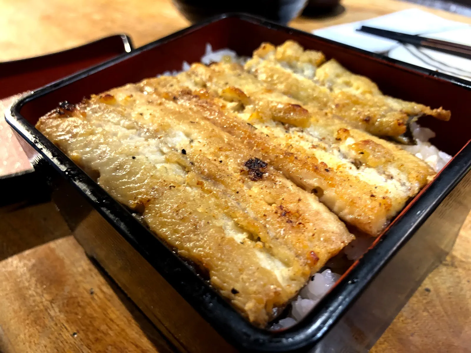 另一盒白燒鰻魚飯，沒有醬色的鰻魚表面帶著烤痕，整片鋪在白飯上