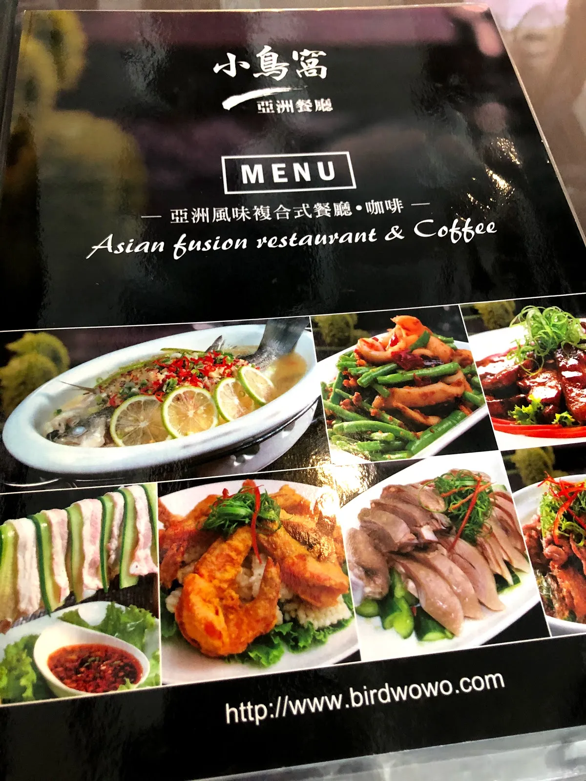 小鳥窩亞洲餐廳的菜單封面，黑色底印著餐廳英文名 Asian fusion restaurant & Coffee，下方是招牌菜色的照片與官網網址