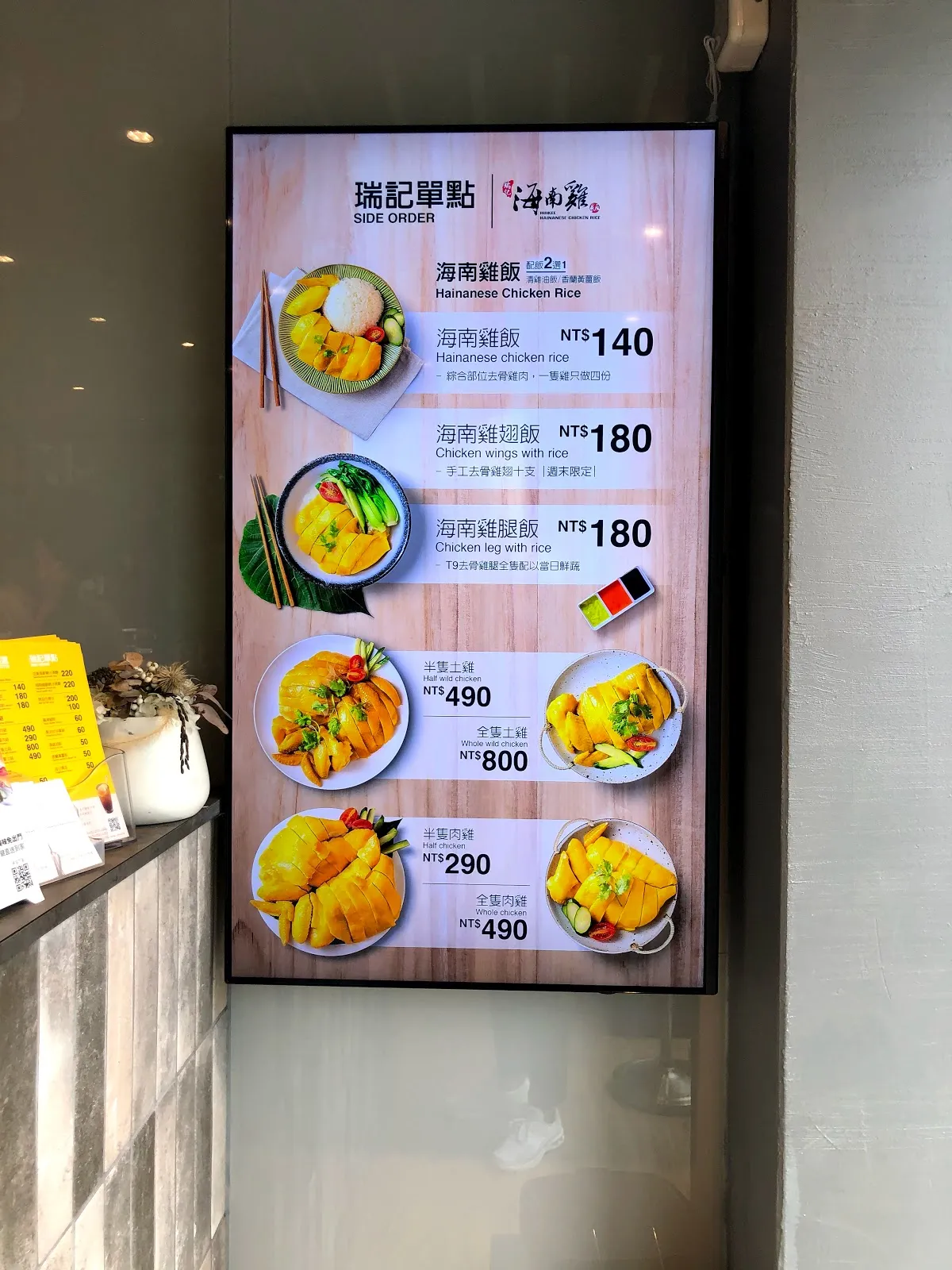 牆上的數位菜單看板，標題是「瑞記單點」，列出海南雞飯 140 元、海南雞翅飯與雞腿飯各 180 元，半雞上味 490 元、全雞 800 元