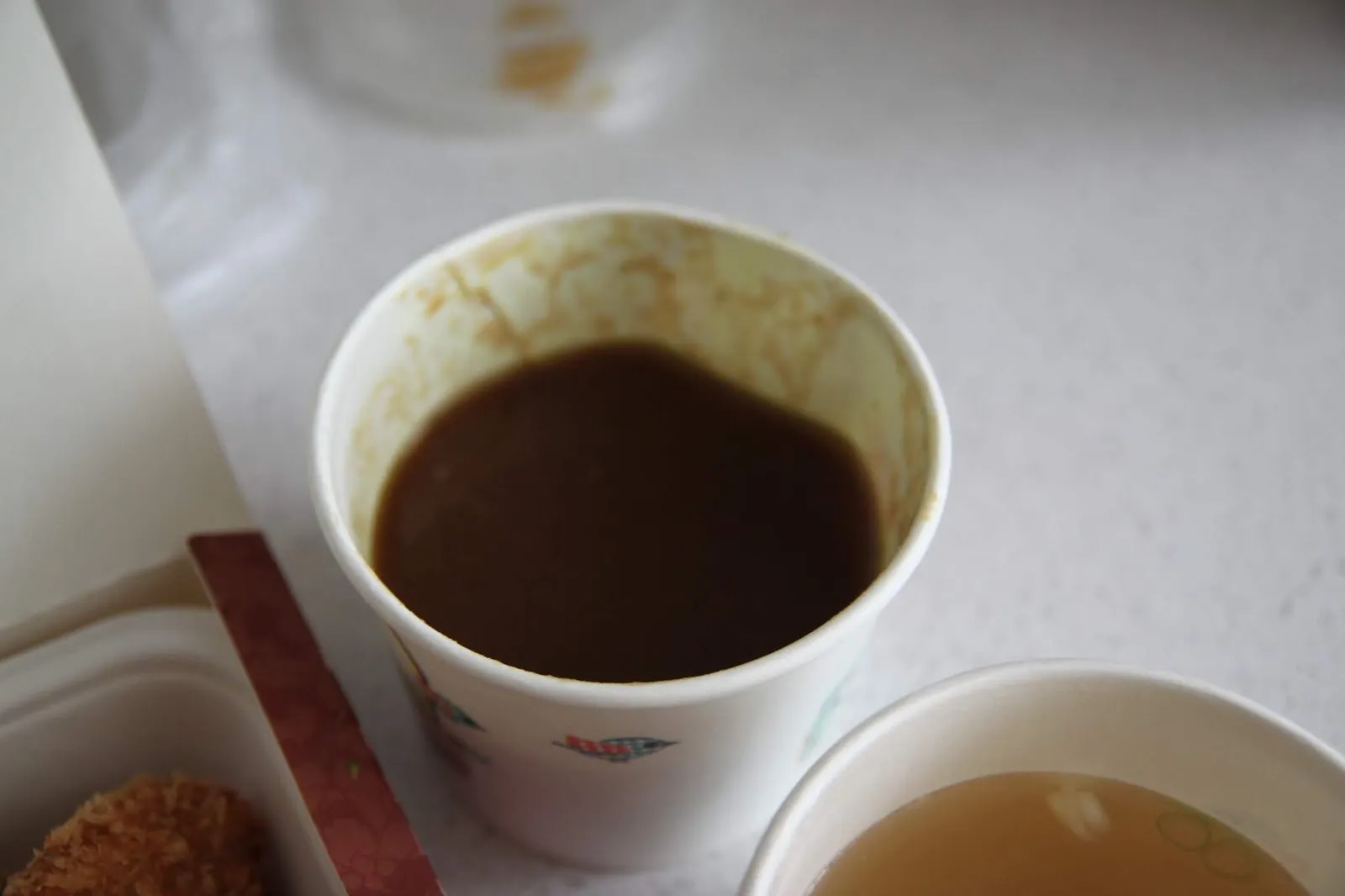 漢堡排附的咖哩醬另外裝在紙杯裡,醬色深褐濃稠,旁邊是一杯清湯