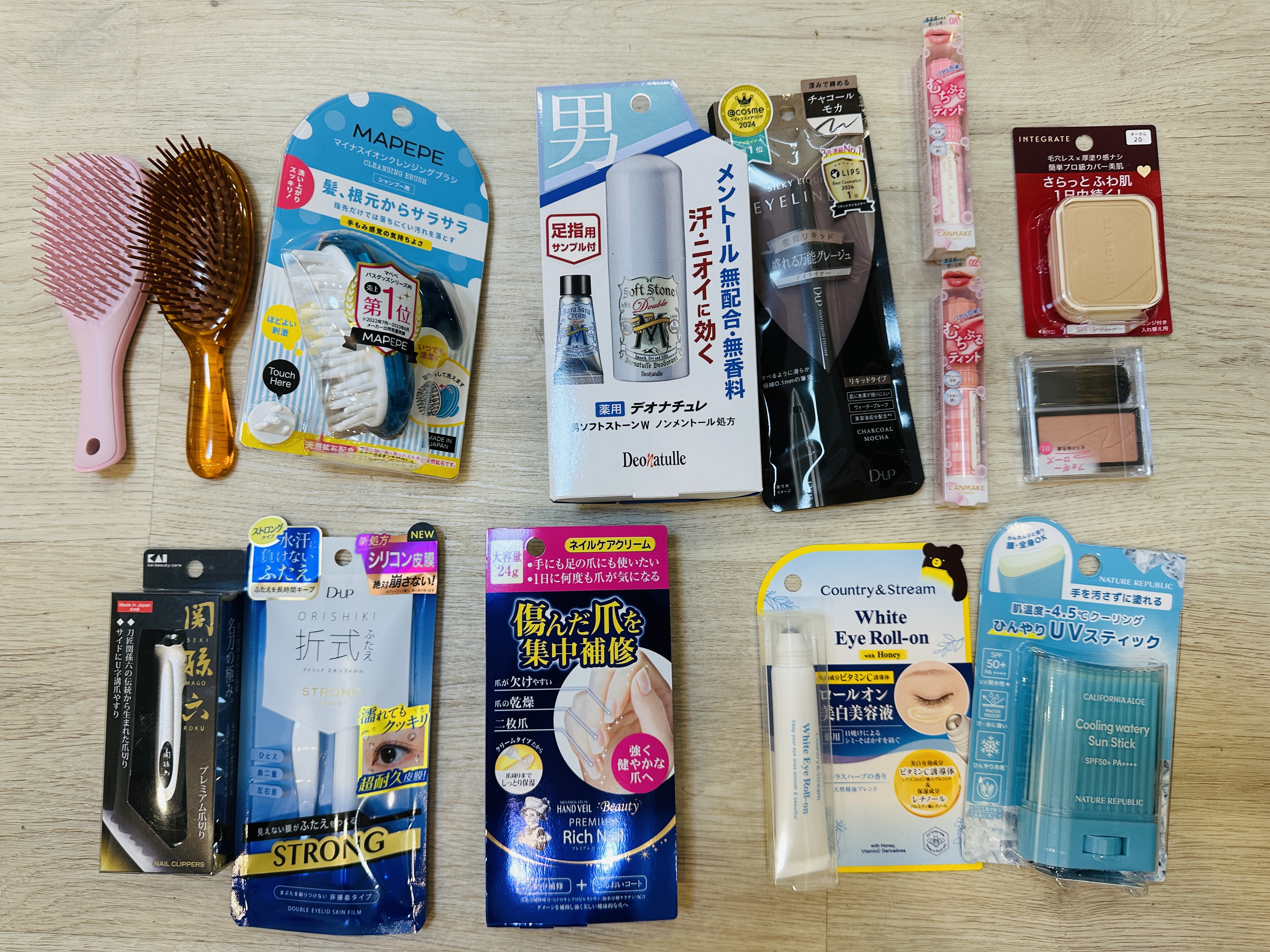 藥妝戰利品，兩支氣墊梳、頭皮按摩刷、男性制汗噴霧、眼線筆、指甲刀、修護指緣霜、美白眼霜與涼感防曬棒