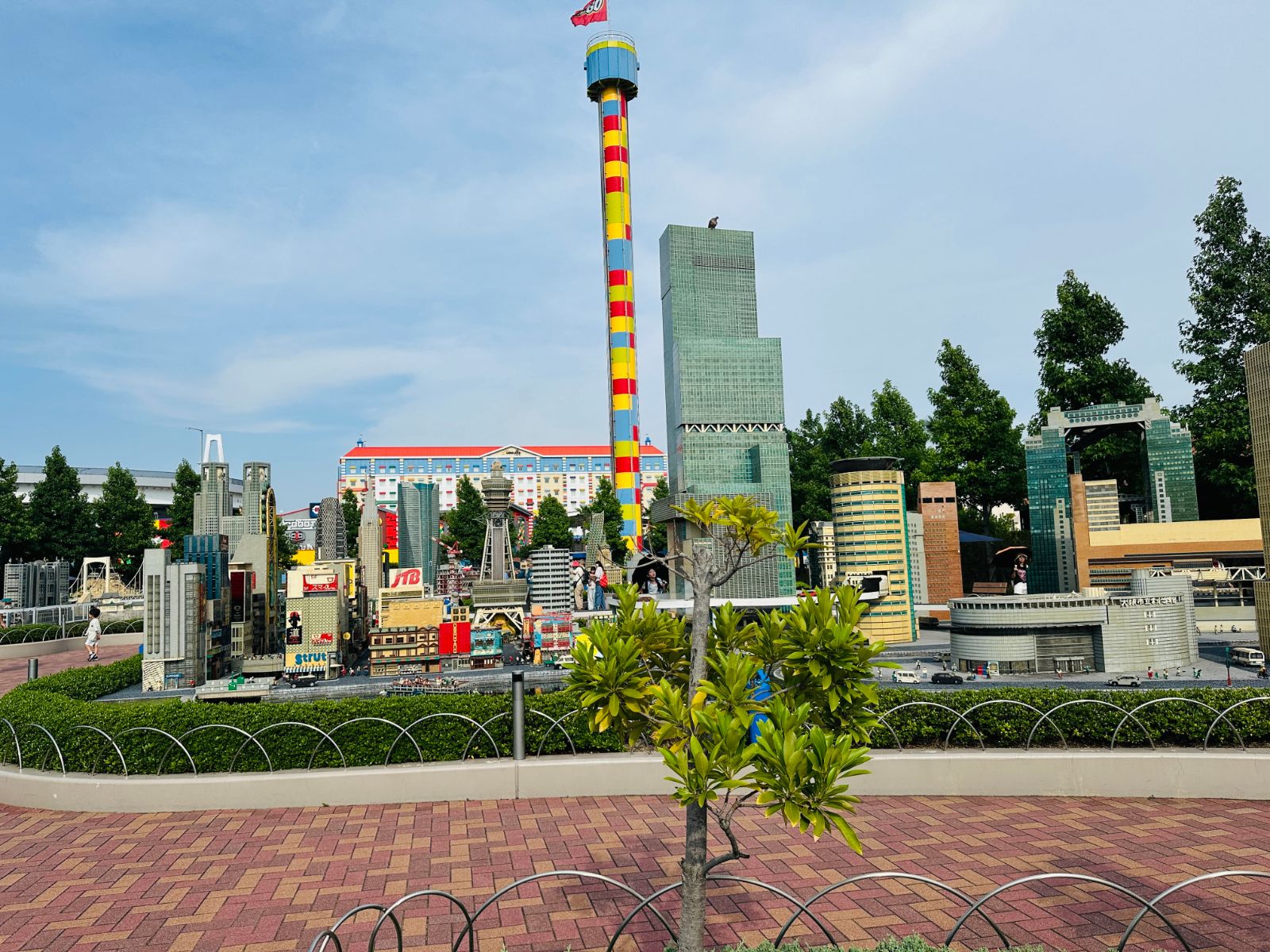 迷你樂園區，用樂高拼成的名古屋市街景，中央是綠色玻璃高樓，後方矗立著紅黃相間的高塔遊具