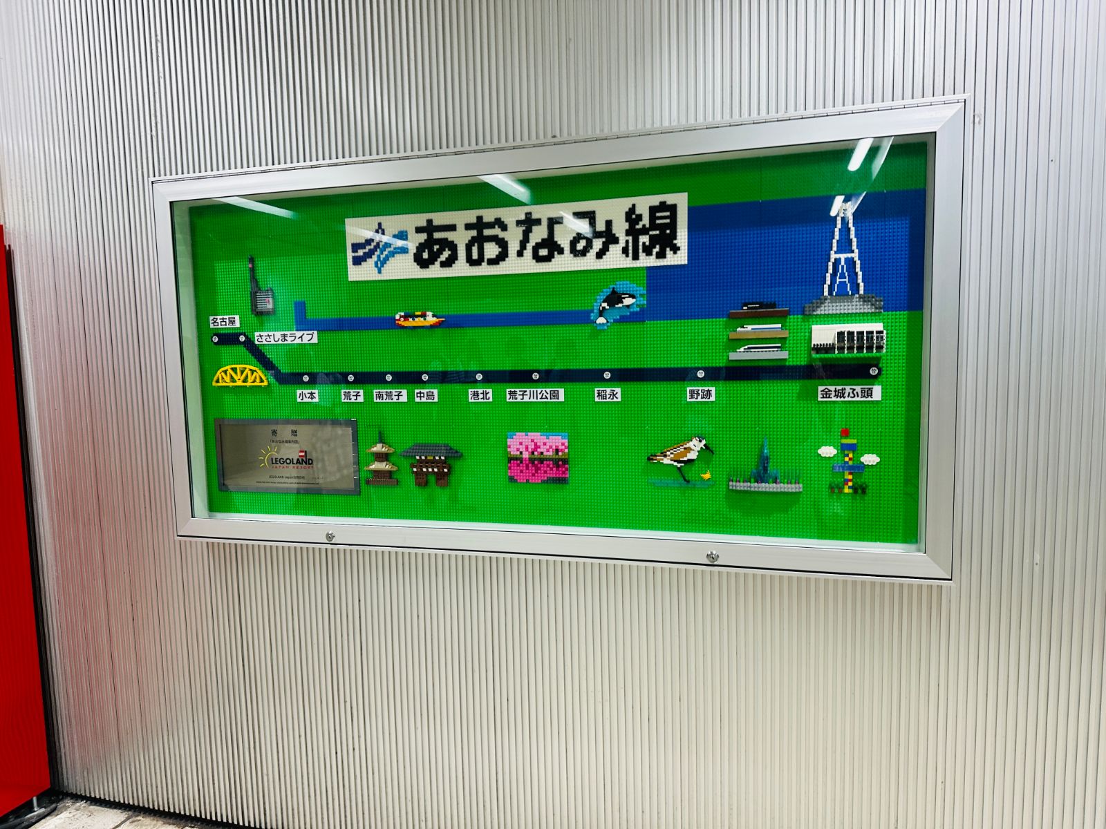 車站牆上用樂高積木拼成的あおなみ線路線圖，綠色底板上排出各站名稱與沿線地標