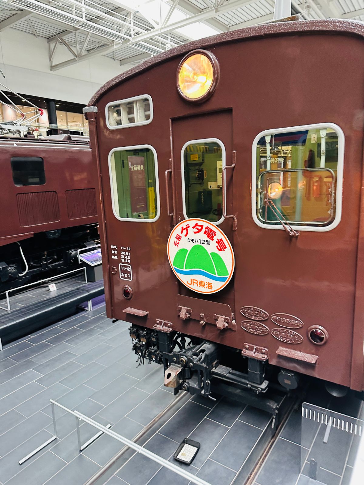 深棕色的舊型電車車頭，正面掛著綠色圓形頭牌，車頂有一盞圓形前燈